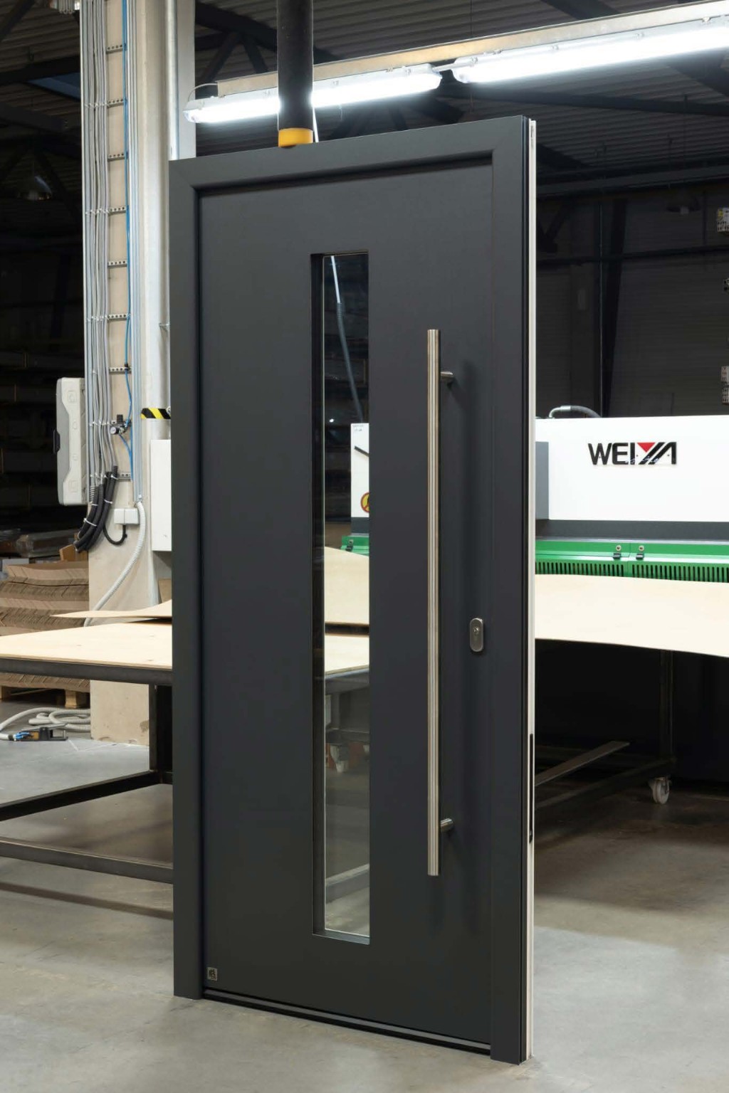 Porte d’entrée anthracite avec vitrage vertical et poignée inox