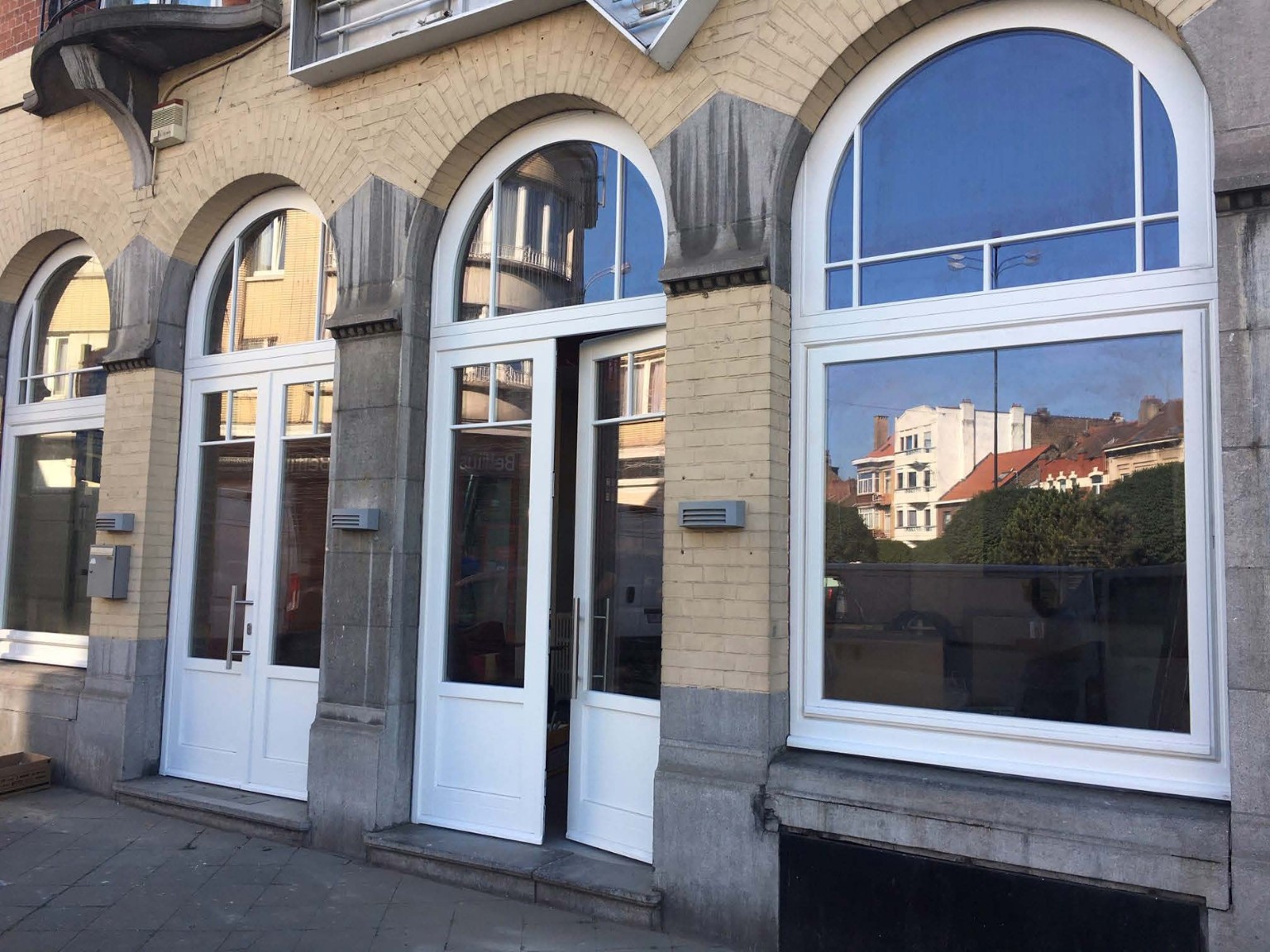 Ensembles de châssis blancs cintrés intégrés à une façade ancienne