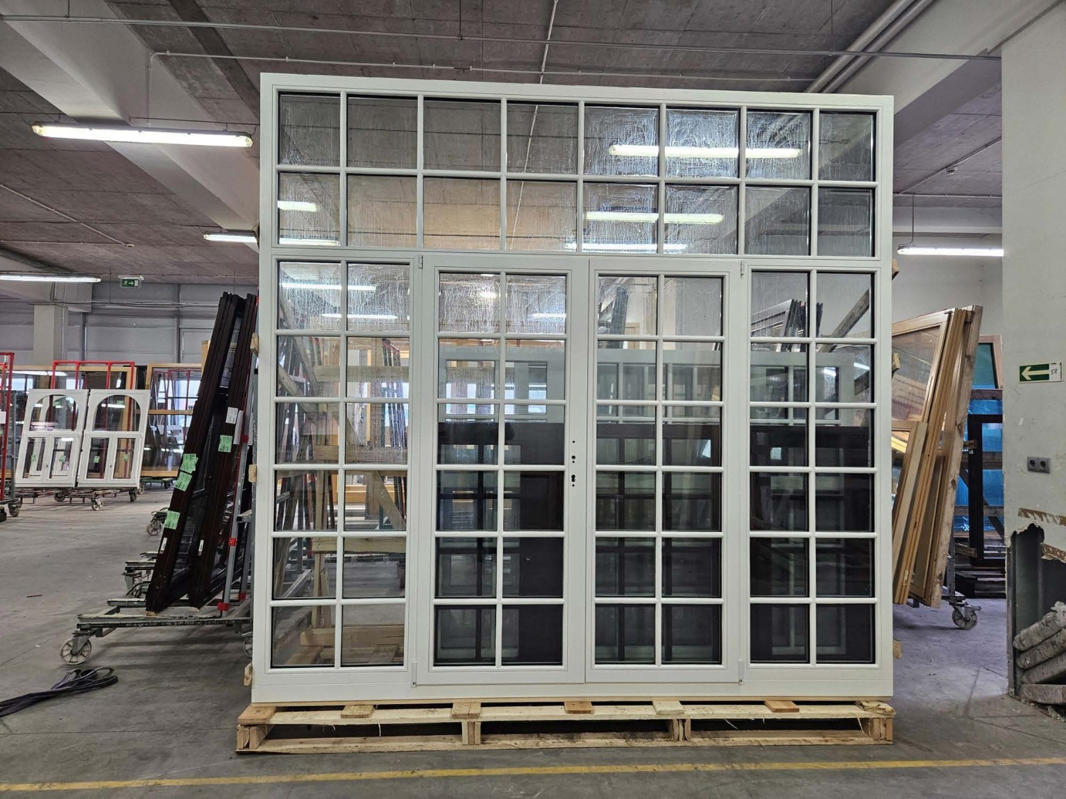Grande menuiserie blanche à petits bois avec portes centrales